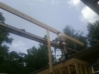 Carpenter setting a ridge beam over a new addition frame — Ice Dam Removal by Roofing Brothers in Uniondale