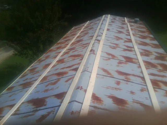 Rusted metal roof panels with new wood purlins before replacement — Storm Damage Roof Repair in Uniondale by Roofing Brothers