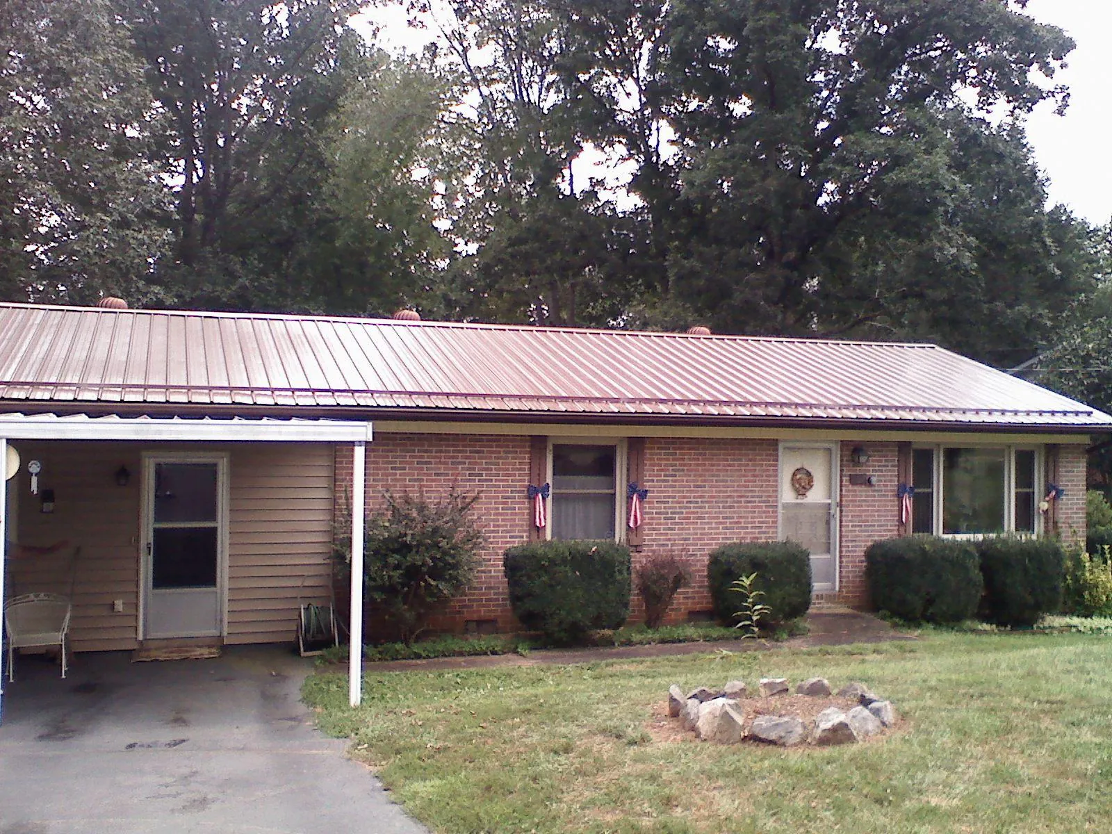 Bronze metal roof and carport on a brick ranch home — Roof Repair work by our crew in Uniondale